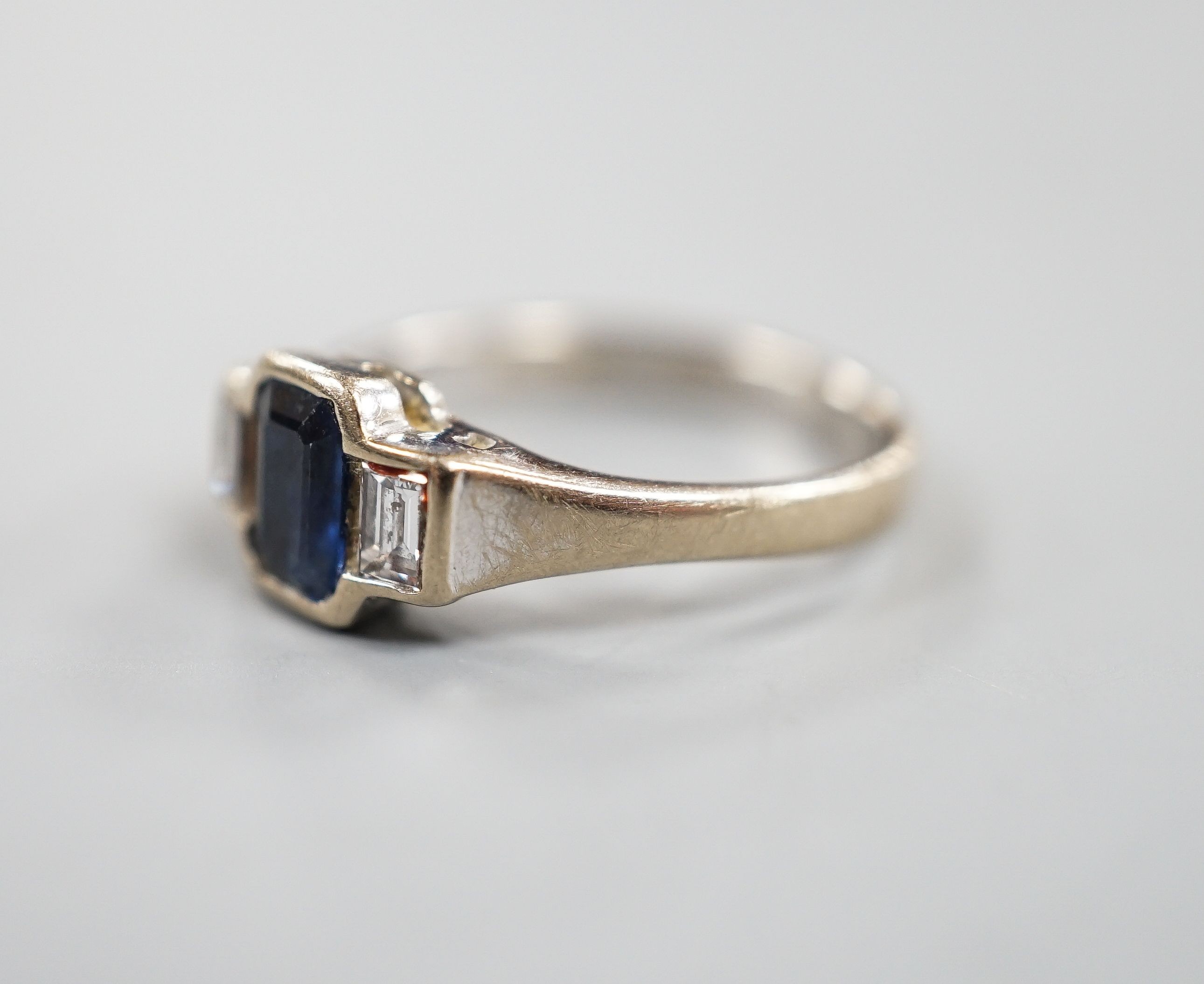 A modern 18ct white gold, collet set sapphire and diamond three stone ring, size L, gross weight 3.8 grams.